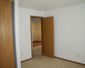 Albert Lea townhouse for rent - a bedroom with a door to a hallway and a closet