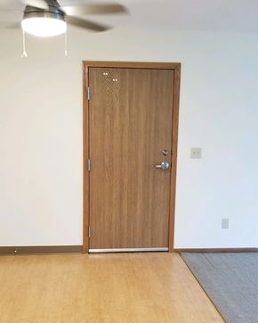 Silver Lake apartment for rent - a wooden door in a room with wood flooring and a ceiling fan