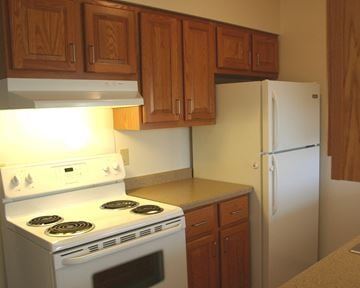 New Prague townhouse for rent - a kitchen with white appliances and wooden cabinets and a refrigerator