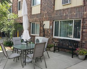 Buffalo apartment for rent - a patio with a table and chairs outside of a brick building