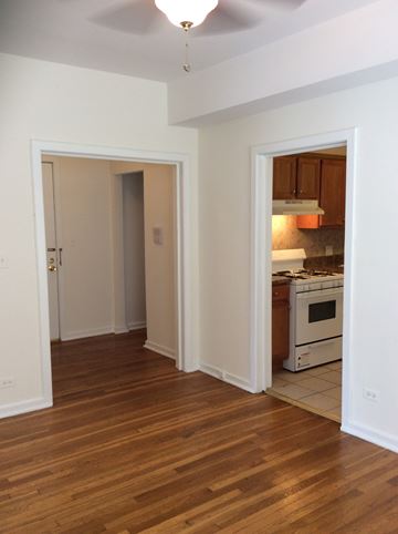 Evanston apartment for rent - an empty living room with a wood floor and a kitchen