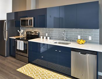 Glossy kitchen cabinets in white or navy blue, along with porcelain tile backsplashes