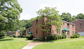 Roslyn apartment for rent - a brick apartment building with green grass and trees