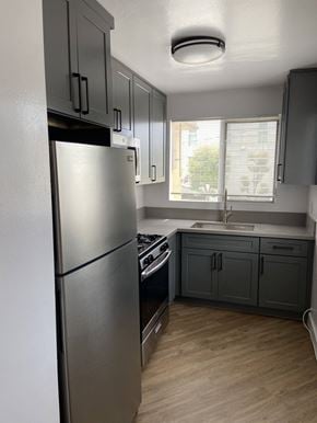 Los Angeles apartment for rent - a kitchen with gray cabinets and a stainless steel refrigerator