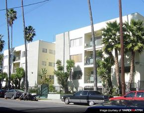 Los Angeles apartment for rent - a building with palm trees and cars parked in front of it