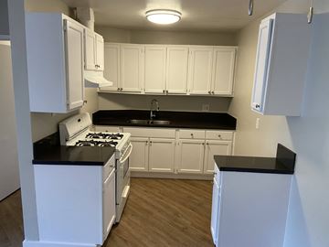 Los Angeles apartment for rent - a kitchen with white cabinets and a stove and a sink