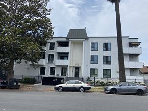 Los Angeles apartment for rent - a white apartment building with two cars parked in front of it