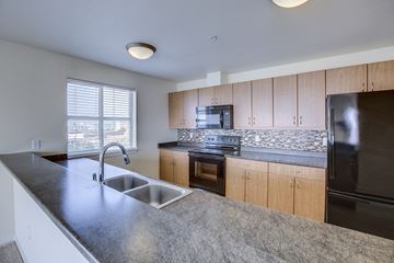 Seattle apartment for rent - an empty kitchen with granite counter tops and a sink