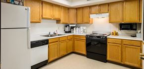 Ada apartment for rent - a kitchen with black and white appliances and wooden cabinets