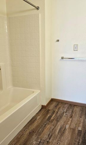 Fosston apartment for rent - A white tiled shower area with a wooden floor.