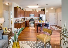 Shelton apartment for rent - a kitchen and living room with wood floors and wooden cabinets
