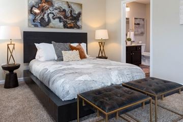 Altoona apartment for rent - A bedroom with a large bed and a painting on the wall.