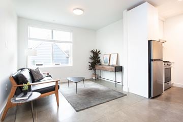 San Francisco apartment for rent - A modern living room with a black and white sofa, a wooden coffee table, and a grey rug.