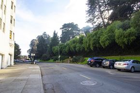 San Francisco apartment for rent - A street with cars parked on the side and a white building on the left.