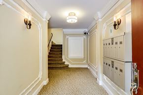 San Francisco apartment for rent - A hallway with a staircase and a wall of mailboxes.