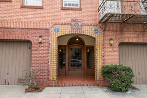 San Francisco apartment for rent - A red brick building with a wooden door and windows.