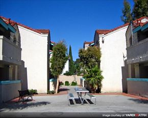 Paramount apartment for rent - a table and chairs in a courtyard between two buildings
