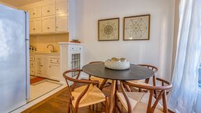 Los Angeles apartment for rent - a dining area with a table and chairs and a kitchen with a refrigerator