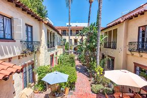 Hollywood apartment for rent - a courtyard with tables and umbrellas in front of a building