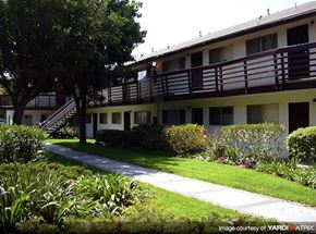 Bellflower apartment for rent - an apartment building with a sidewalk and trees
