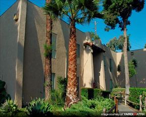 Anaheim apartment for rent - a building with palm trees in front of it