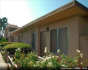 Anaheim apartment for rent - a row of houses with bushes and flowers