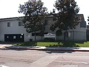 Anaheim apartment for rent - a white building with a sign on the side of a street