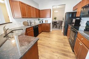 Wilmington triplex for rent - a large kitchen with wooden cabinets and black appliances