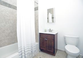 Newton apartment for rent - Bathroom with wooden cabinets and light grey tiles and white walls