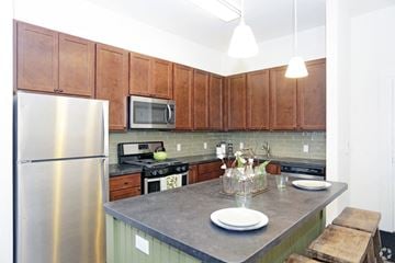 Newton apartment for rent - A kitchen with a stainless steel refrigerator and wooden cabinets.