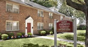 Rahway apartment for rent - a sign in front of a brick apartment building