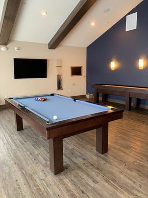 Weston apartment for rent - a pool table in a game room with two tables and a tv