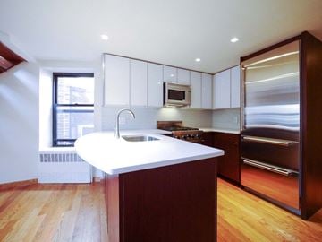 New York apartment for rent - a kitchen with a white counter top and a stainless steel refrigerator
