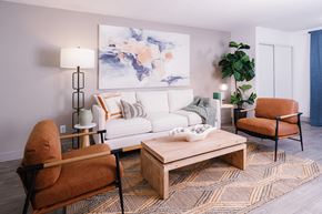 Las Vegas apartment for rent - A living room with a white couch, a brown chair, and a wooden coffee table.