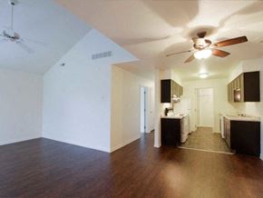 Temperance townhouse for rent - an empty living room and kitchen with a ceiling fan