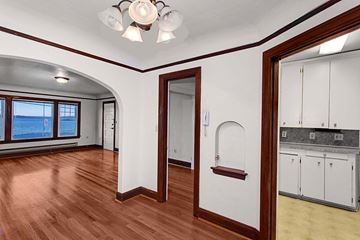Seattle apartment for rent - the living room and kitchen of a house with wooden floors and white walls