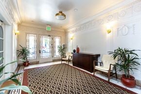 San Francisco apartment for rent - A room with a patterned carpet and a wooden cabinet.