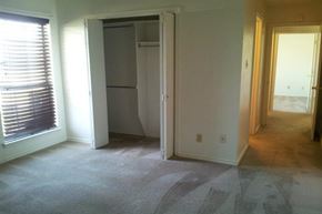 Denton triplex for rent - an empty living room with a closet and a window