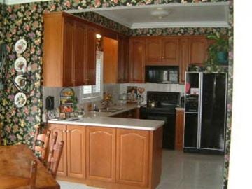 Markham apartment for rent - A kitchen with wooden cabinets and a black refrigerator.