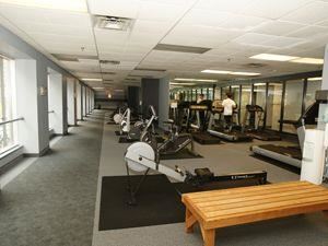 Toronto apartment for rent - A gym with a variety of equipment including treadmills, weights, and a bench.