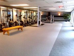 Toronto apartment for rent - A gym with a variety of equipment including treadmills, weights, and a bench.