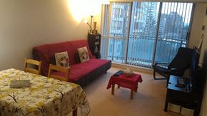 Toronto apartment for rent - A bedroom with a bed, a couch, a chair, a small table, and a television.
