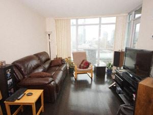 Toronto apartment for rent - A living room with a brown leather couch and a wooden coffee table.
