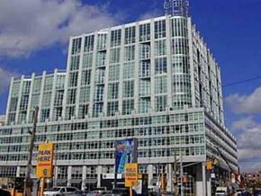 Toronto apartment for rent - A large glass building with a sign that says "PARK HERE" on the side.