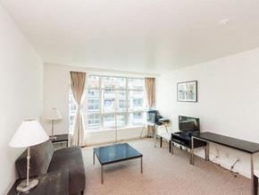 Toronto apartment for rent - A living room with a couch, a chair, a coffee table, a television, and a window with curtains.