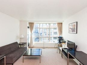 Toronto apartment for rent - A living room with a couch, a chair, a coffee table, and a television.
