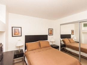 Toronto apartment for rent - A bedroom with a bed, nightstand, and lamp.