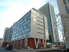 Toronto apartment for rent - A modern building with a glass facade and a white and red exterior.