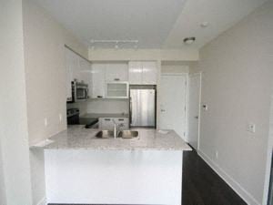 Toronto apartment for rent - A kitchen with white cabinets and a white island.