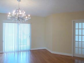 Toronto apartment for rent - A room with a chandelier and a window with blinds.